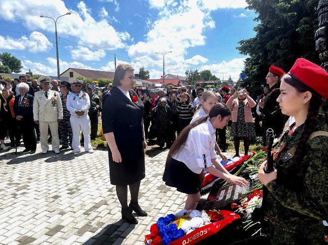 глава Ладожского сельского поселения Татьяна Марчук и ученики школы № 19 возлагают цветы к подножию памятника погибшим на СВО в станице Ладожской