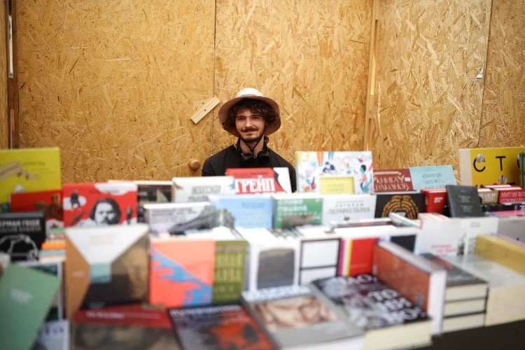 мужчина за прилавком с книгами в павильоне книжного магазина "Чарли" на фестивале "Александровская крепость" в Усть-Лабинске