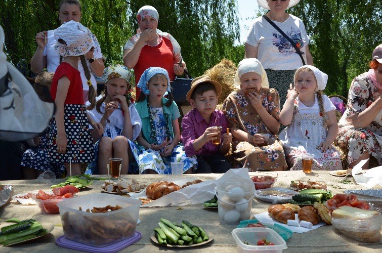 дети угощаются за троицким общим столом