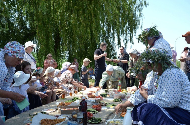 накрытый на траве стол с угощениями для детей и взрослых