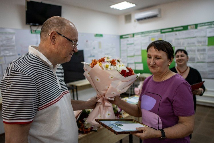 директор АО «Рассвет» Анатолий Ротко дарит животноводу Светлане Рыжовой цветы и вручает благодарственное письмо с подарочным сертификатом