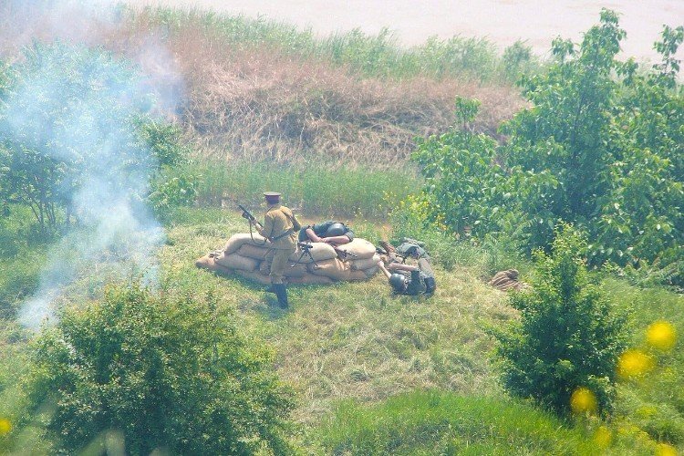 сцена реконструкции: советские солдаты атакуют укрепление немецких захватчиков на холме
