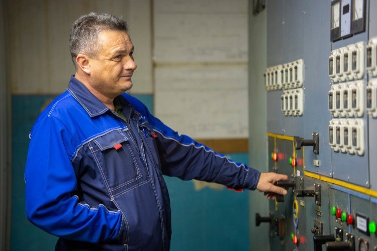 рабочий проверяет пульт управления