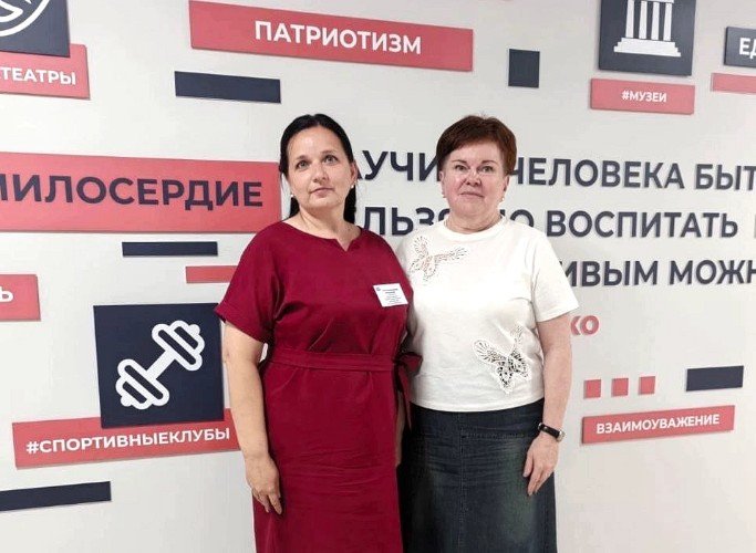 Педагоги холдинга «Детство без границ» стоят на фоне плаката