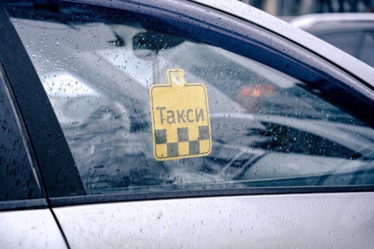 Автомобиль такси стоит под дождем