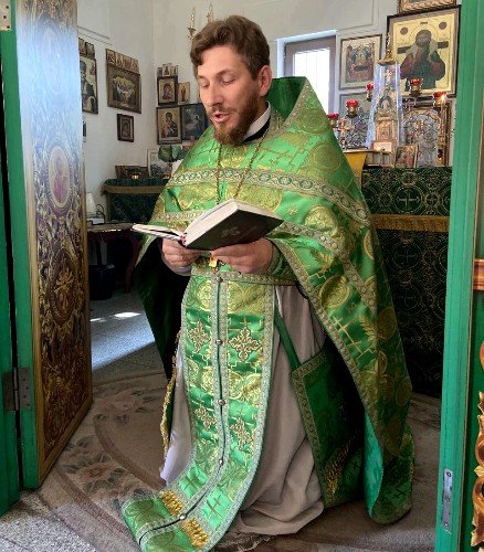 священник Дионисий Шиегин на коленях читает молитву