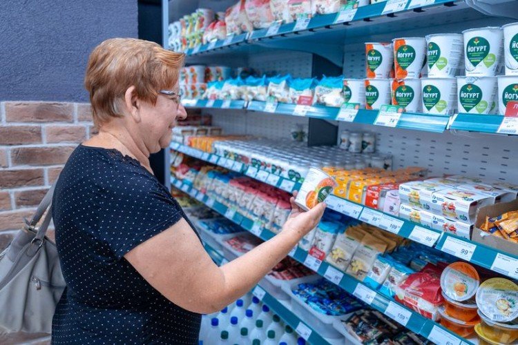 женщина рассматривает продукт с прилавка