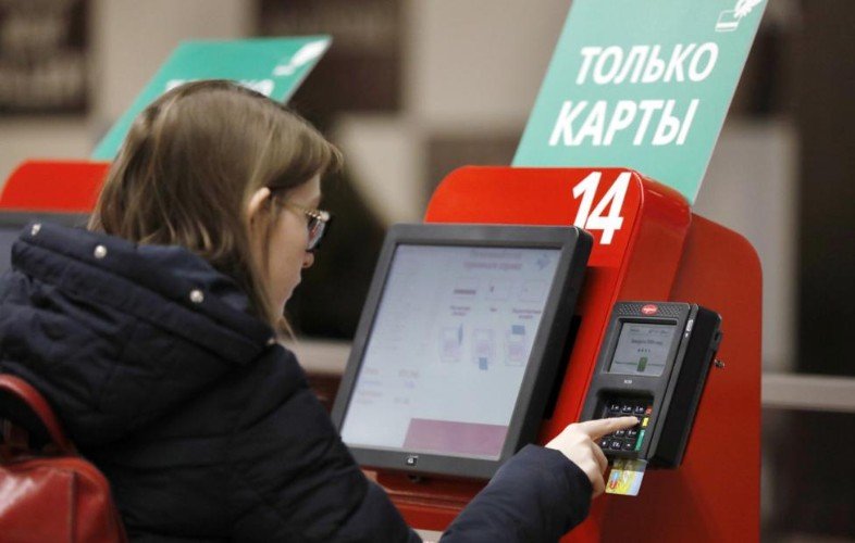 Девушка у кассы самообслуживания.