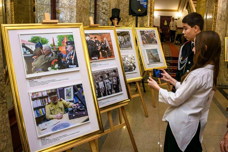 Фоторабота «Связь времён: война и музыка» Елены Зинкевич крайняя слева в нижнем ряду - в холле  краснодарской филармонии
