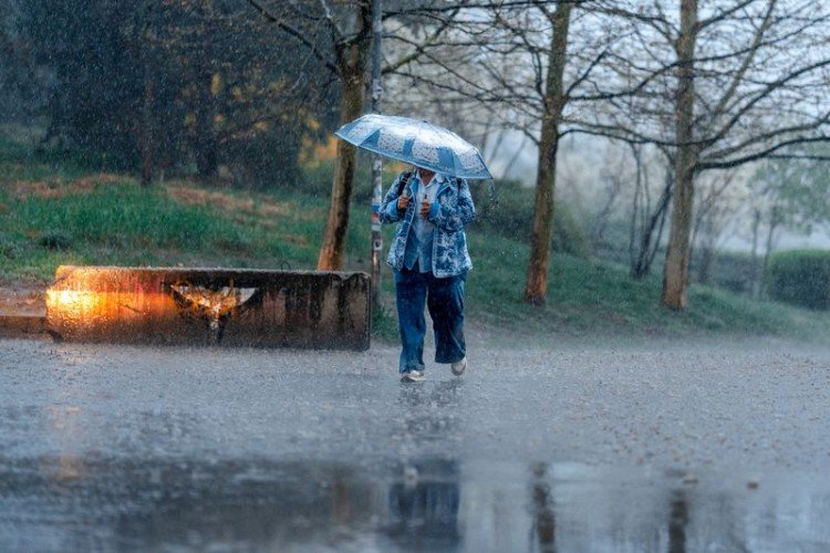 Человек с зонтом под дождём