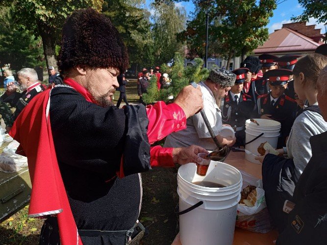 Казаки наливают чай и угощают кашей