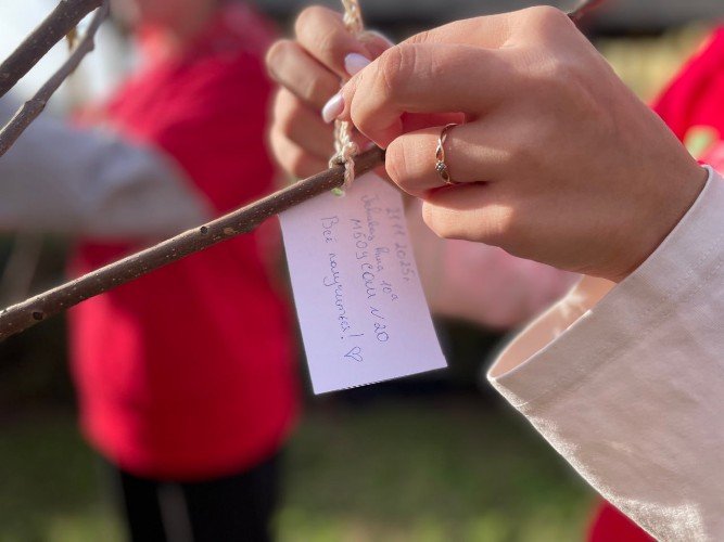 девушка привязывает на ветку записку