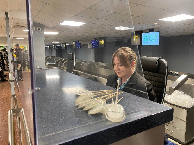 Женщина сидит за стойкой регистрации