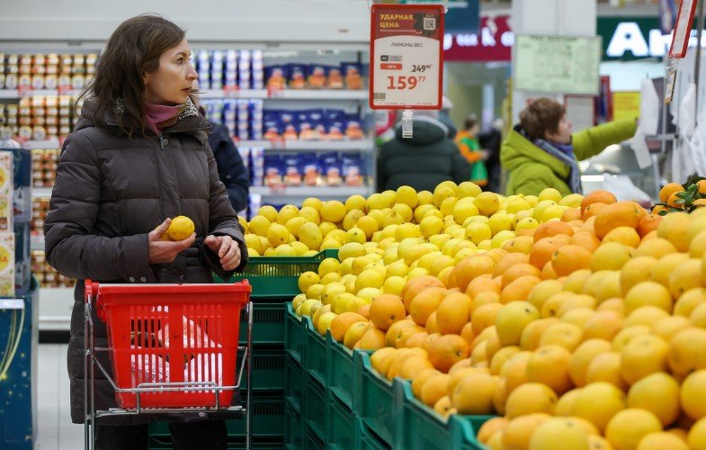 Женщина с тележкой в супермаркете