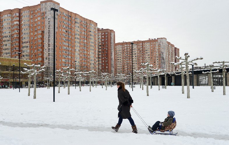 Женщина и ребёнок на санках в парке