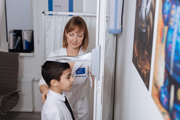 Врач измеряет рост мальчика