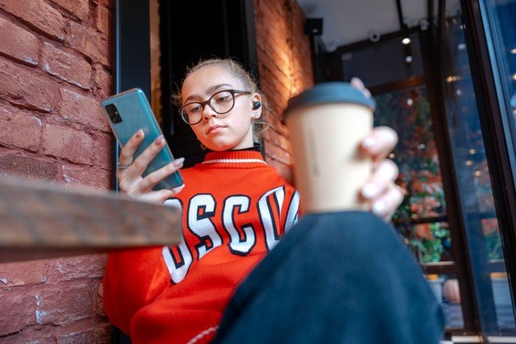 Девушка с кофе и телефоном