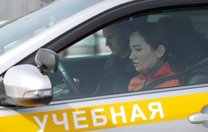 Девушка за рулём учебной машины