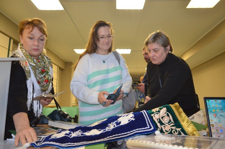 Женщины разглядывают работы народных мастеров