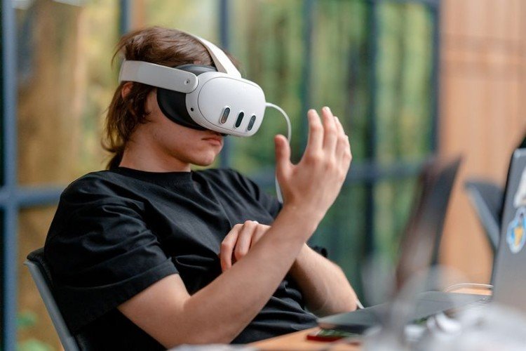 Подросток за компьютером в очках виртуальной реальности