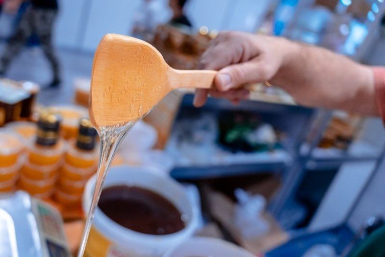 Мёд льётся с деревянной лопатки