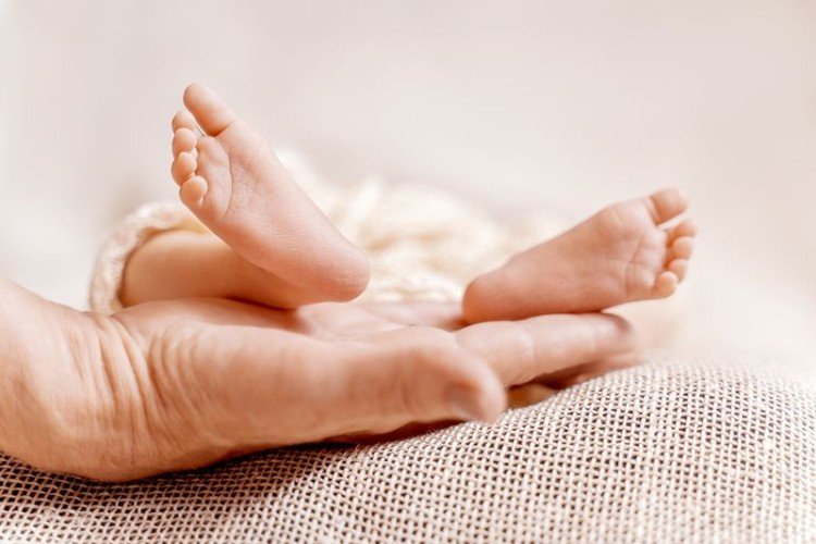 Ножки младенца в женской руке