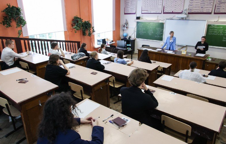 Школьники в классе и учитель у доски