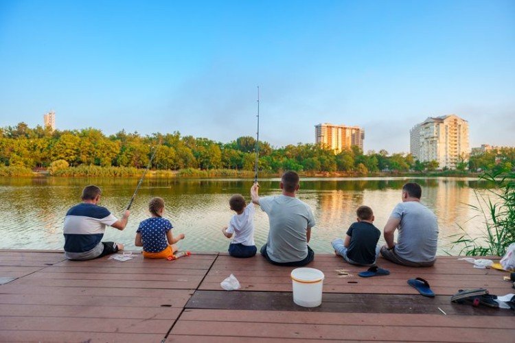 Взрослые и дети на берегу озера