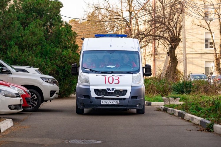 машина скорой помощи едет по дороге во дворе многоэтажек