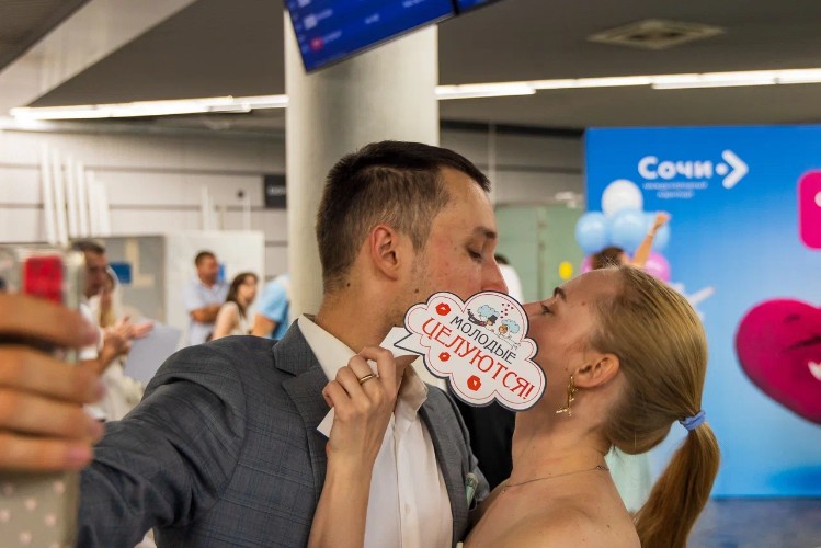 жених и невеста целуются в аэропорту Сочи
