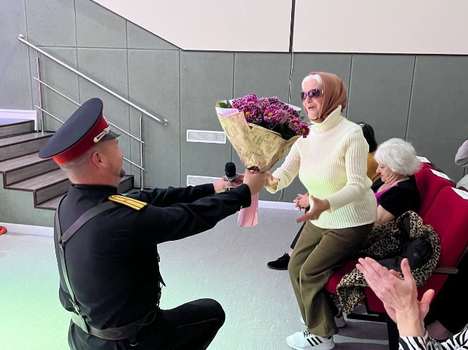 Цветы ветерану коллектива Вере Глазковой дарит солист Алексей Понаморёв