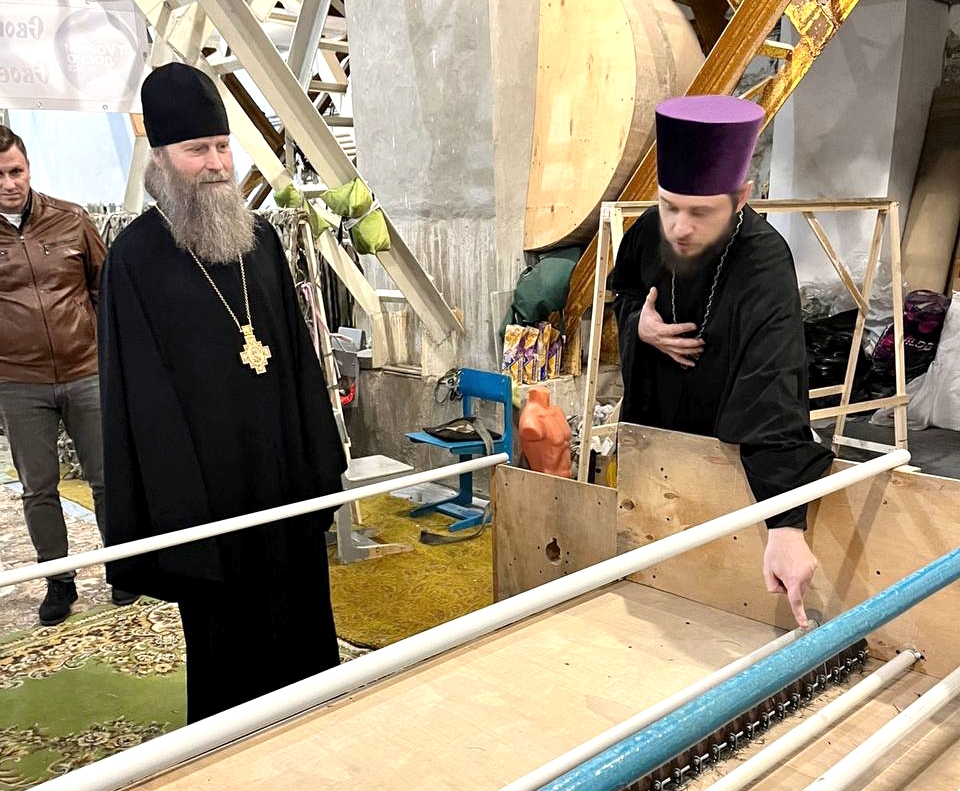 настоятель Сергиевского храма иерей Дионисий Хизуненко показывает епископу Силуану станок для нарезки ткани