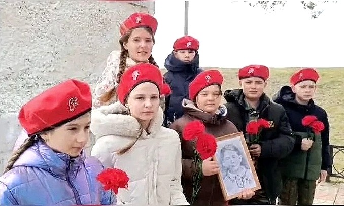 юнармейцы с портретом Муси Пинкензона на памятнике погибшим устьлабинцам
