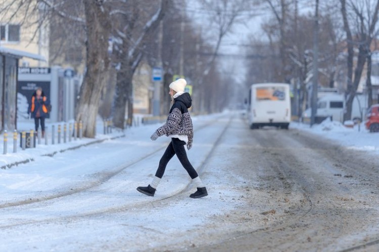Девочка переходит заснеженную дорогу
