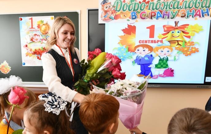 Учитель с букетами и дети