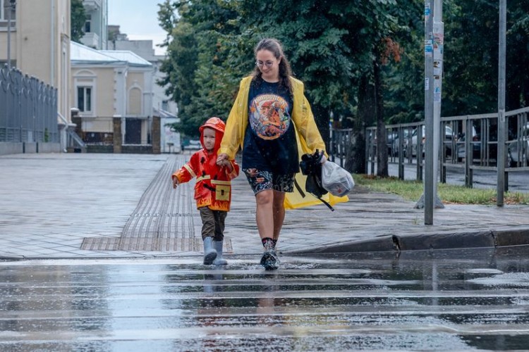 Женщина с ребёнком шагают по лужам